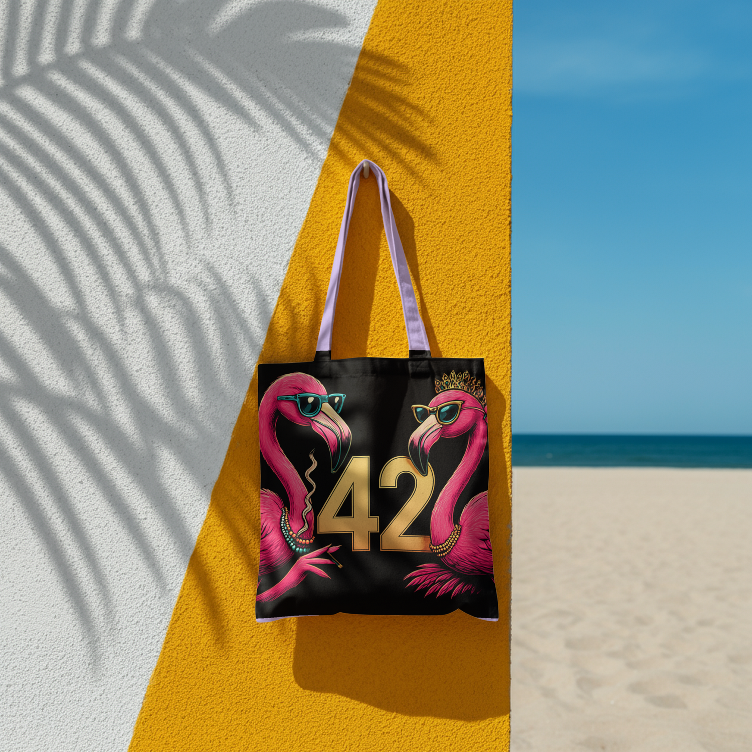 Eine Tragetasche hängt an einer Wand am Strand, darauf sind 2 Flamingos gedruckt