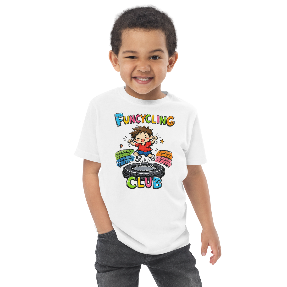 Ein Junge trägt ein weißes T-Shirt mit buntem "Funcycling Club" Print und einem Jungen der auf einem Reifen Trampolin springt