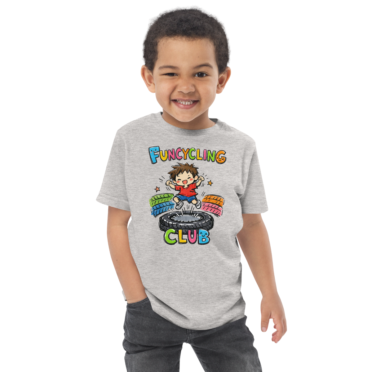 Ein Junge trägt ein graues T-Shirt mit buntem "Funcycling Club" Print und einem Jungen der auf einem Reifen Trampolin springt