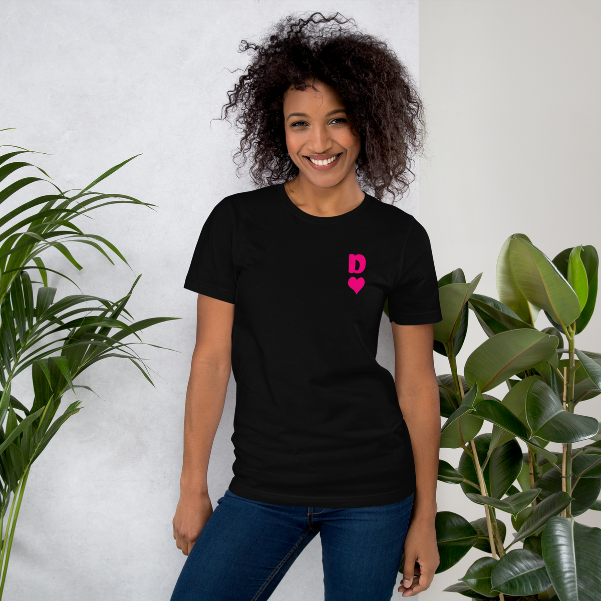 Frau trägt schwarzes Partnerlook Unisex T-Shirt mit minimalistischem pinkem Dame Herz Symbol