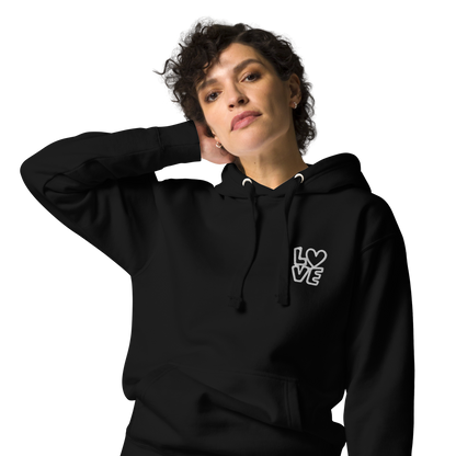 Frau trägt schwarzen Hoodie mit kleinem gestickten LOVE bei dem das O durch Herz ersetzt ist