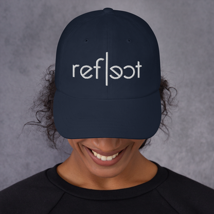 Frau trägt navy farbendes Cap mit weißem reflect Schriftzug, gestickt
